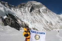 Kami Sherpa holds up Rotary banner, with Mt. Everest in the background